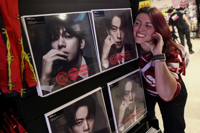 지난달 20일 영국 런던에서 BTS의 한 팬이 새 앨범과 함께 사진을 찍고 있다. 로이터연합뉴스