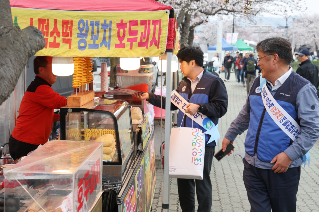 한수원 임직원들이 경주 황리단길에서 상인에게 에너지 절약 캠페인을 안내하고 있다. 한수원 제공