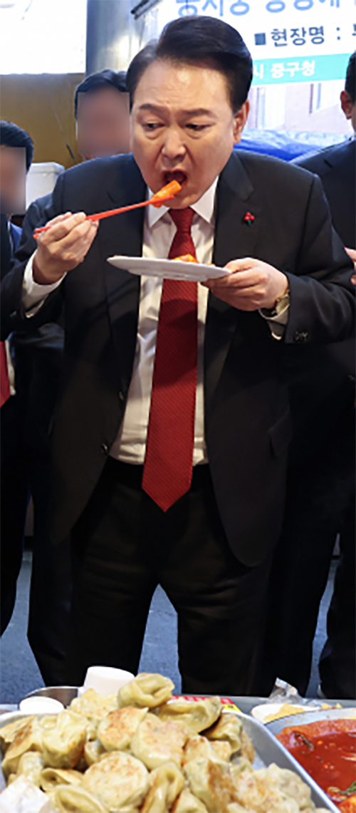 2023년 12월 당시 윤석열 대통령이 부산 중구 깡통시장에서 떡볶이을 맛보고 있다. 연합뉴스