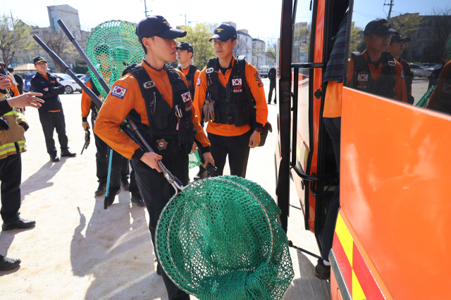 8일 대전 중구 사정동 오월드에서 늑대 1마리가 탈출해 인근 초등학교에서 목격 신고가 접수된 가운데, 이날 오후 이 학교 교내에서 소방 대원들이 포획망을 들고 출동을 준비하고 있다. 연합뉴스
