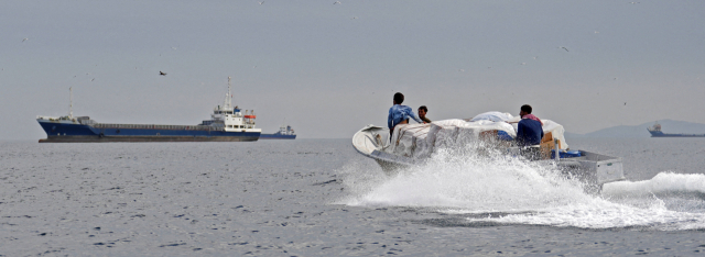 12일(현지 시간) 호르무즈해협 인근에서 유조선을 비롯한 선박들이 고립된 가운데, 선원들에게 전달될 물품이 소형 보트에 실려 운반되고 있다. 로이터연합뉴스