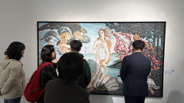 지난 7일 금정문화회관 금샘미술관에서 개막한 ‘지구 앞에 서다_위태로운 경계에서’ 선보인 크리스 조던의 '비너스'(2011)를 살펴보는 관람객들. 보티첼리의 명화 ‘비너스의 탄생’을 차용한 이 작품은 24만 개의 비닐봉지로 만들어졌다. 김은영 기자 key66@