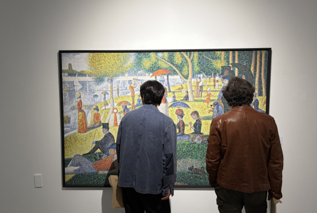 크리스 조던의 ‘캡스 쇠라’(Caps Seurat)를 살펴보는 관람객들. 조르즈 쇠라의 명작 ‘그랑드자트섬의 일요일 오후’를 차용한 이 작품은 40만 개의 병뚜껑으로 만들어졌다. 김은영 기자 key66@