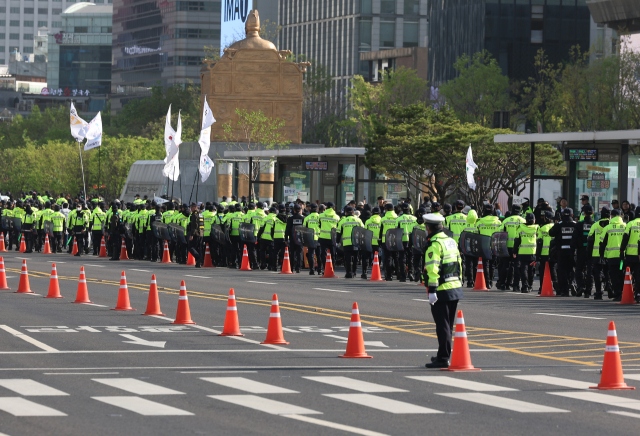 전국장애인차별철폐연대(전장연) 등 207개 단체로 구성된 '4·20 장애인차별철폐 공동투쟁단'이 장애인의 날인 20일 서울 종로구 광화문 서십자각 인근에서 연 결의대회에서 참가자들이 행진하는 동안 경찰이 주변을 통제하고 있다. 연합뉴스