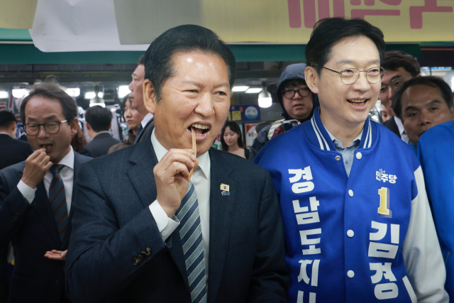 더불어민주당 정청래 대표가 22일 민주당 김경수 경남도지사 후보와 경남 통영중앙전통시장을 방문해 말린 오징어를 먹어보고 있다. 연합뉴스