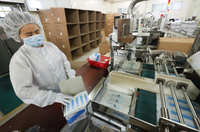 15일 경기도 안산시 단원구 한국백신 공장에서 완성된 주사기의 포장 작업이 진행되고 있다. 연합뉴스