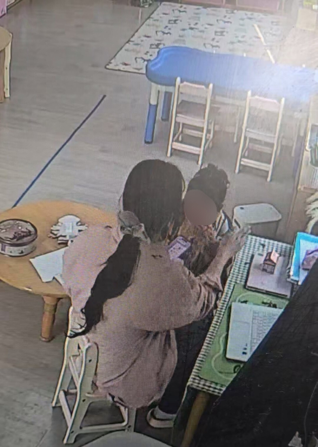 지난달 25일 오후 부산 한 국공립 어린이집 CCTV에 찍힌 보육교사 A 씨가 손으로 5세 원아 B 양의 팔을 때리는 모습. 학부모 제공