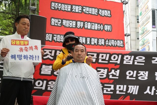 국민의힘 함안군수 이성용 전 예비후보가 경남도당 앞에서 삭발식을 진행하는 모습。 연합뉴스
