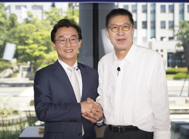 18일 오전 부산 남구 국립부경대 대연캠퍼스에서 열린 국제신문 주최 부산시장 후보 토론회에서 더불어민주당 전재수 후보와 국민의힘 박형준 후보가 토론 시작 전 손을 맞잡고 있다. 연합뉴스