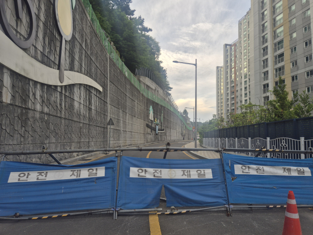 19일 오후 부산 부산진구 초읍동의 한 아파트 단지 인근 도로 모습. 재개발 사업이 추진되는 과정에서 재개발 조합과 인근 유명 사찰 사이 법적 분쟁으로 2020년 도로 개설 이후 6년 넘게 차량 진출입이 차단됐다. 김동우 기자 friend@