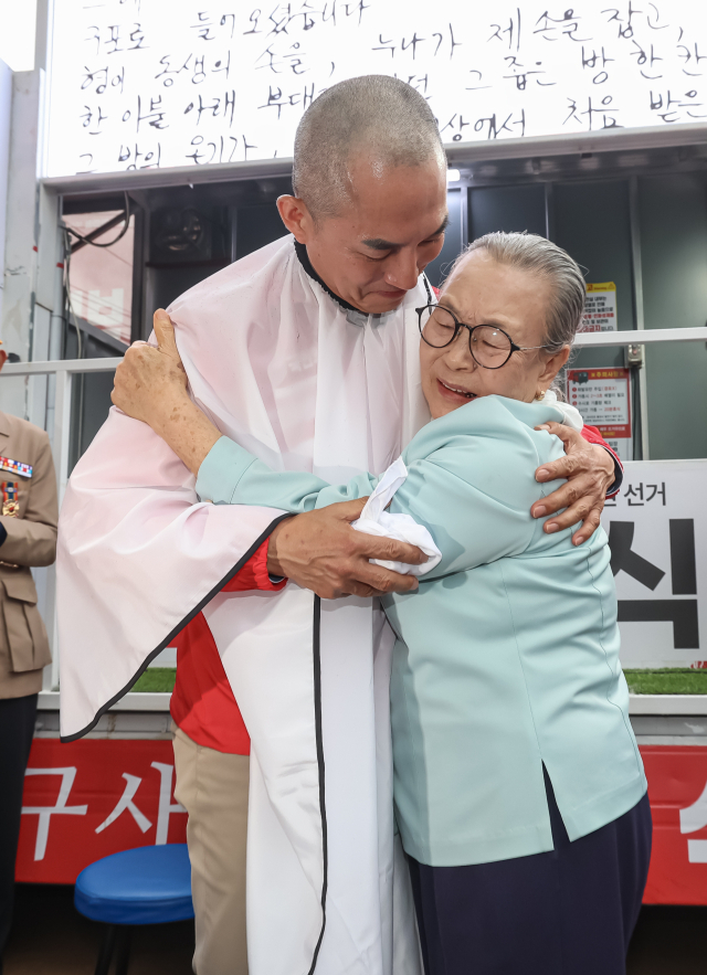 국민의힘 박민식 북갑 보궐선거 후보가 21일 오후 부산 북구 쌈지공원에서 열린 출정식에서 삭발을 마치고 모친과 포옹하고 있다. 김종진 기자 kjj1761@