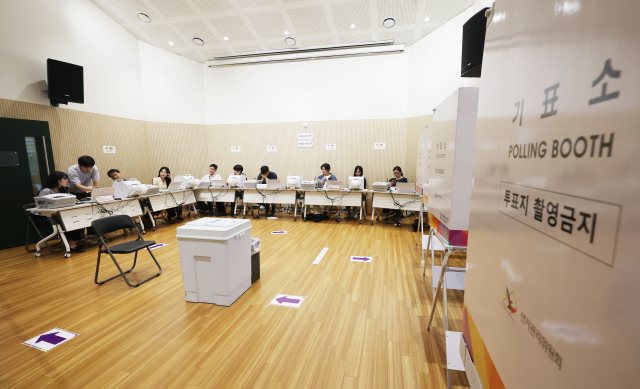 제9회 전국동시지방선거 사전투표를 하루 앞둔 28일 서울 종로동 사직동 주민센터에 설치된 사전투표소에서 선관위 관계자가 분주히 움직이고 있다. 연합뉴스