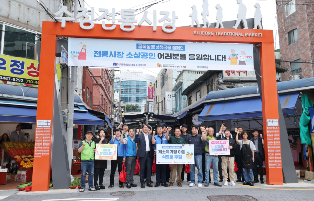 노조 관계자들과 시장 상인들이 함께 파이팅을 외치고 있다. 이날 시장에서 산 물품은 초록우산을 통해 아동지원시설 등에 기부한다. 정종회 기자 jjh@